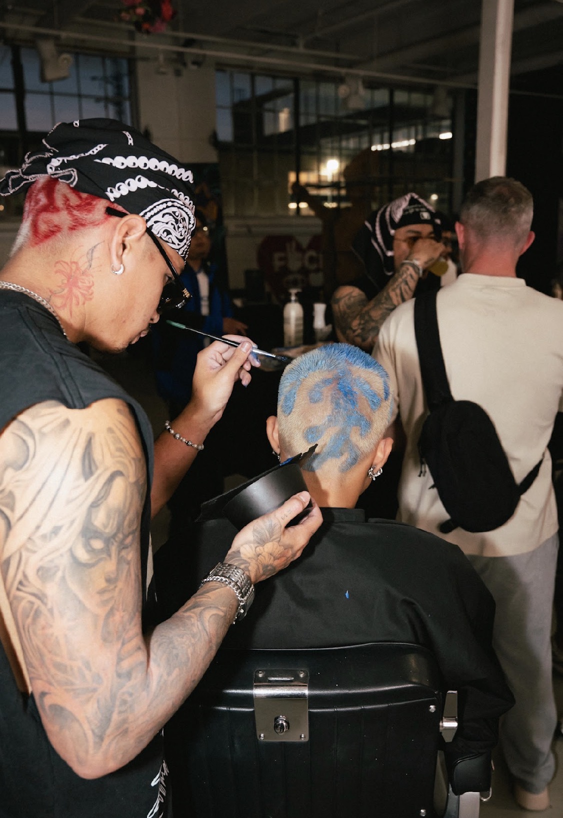 Artist hand-painting blue colour into a fresh fade at fyf North