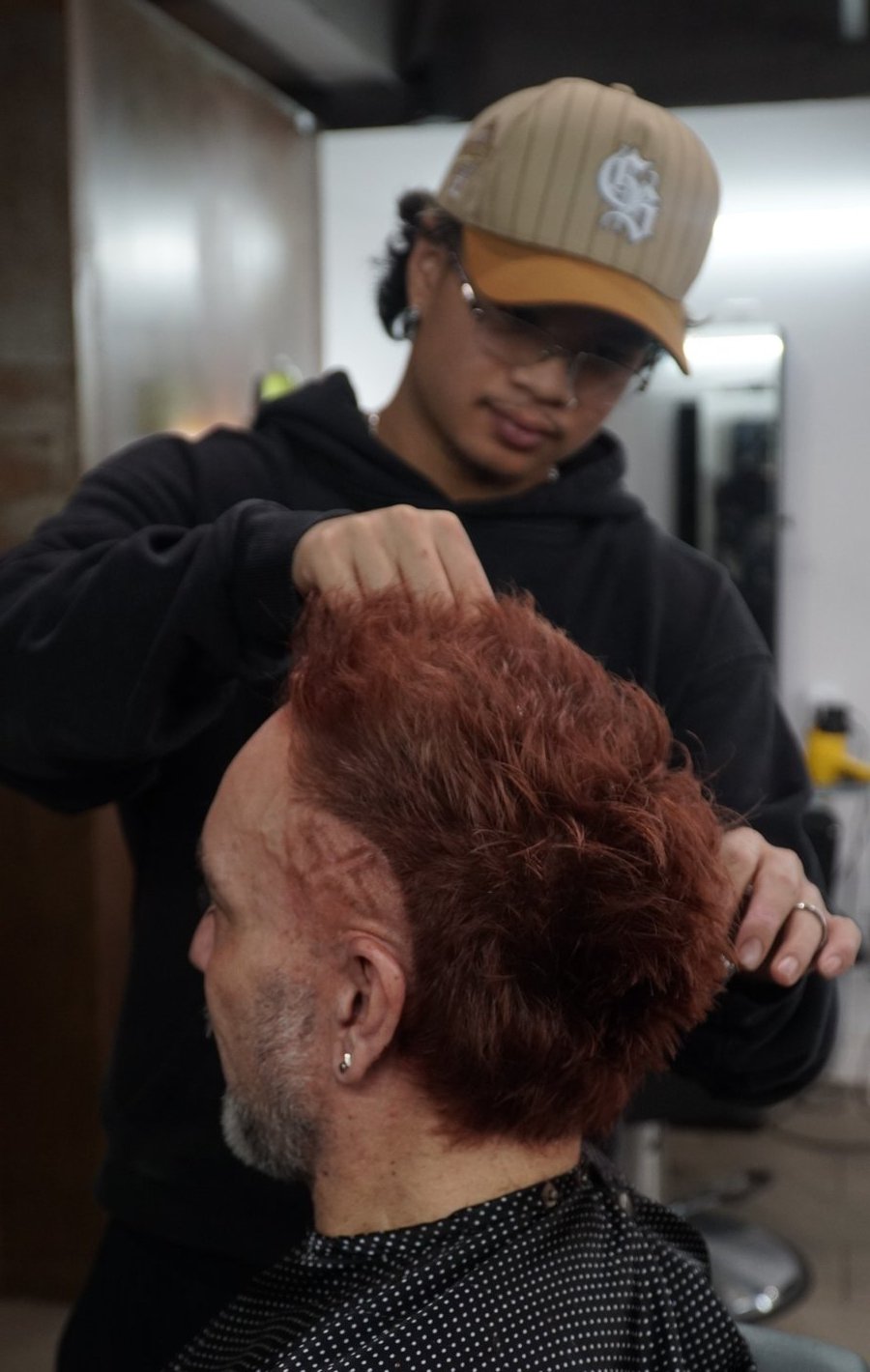 Barber working on a red colour transformation at fyf North