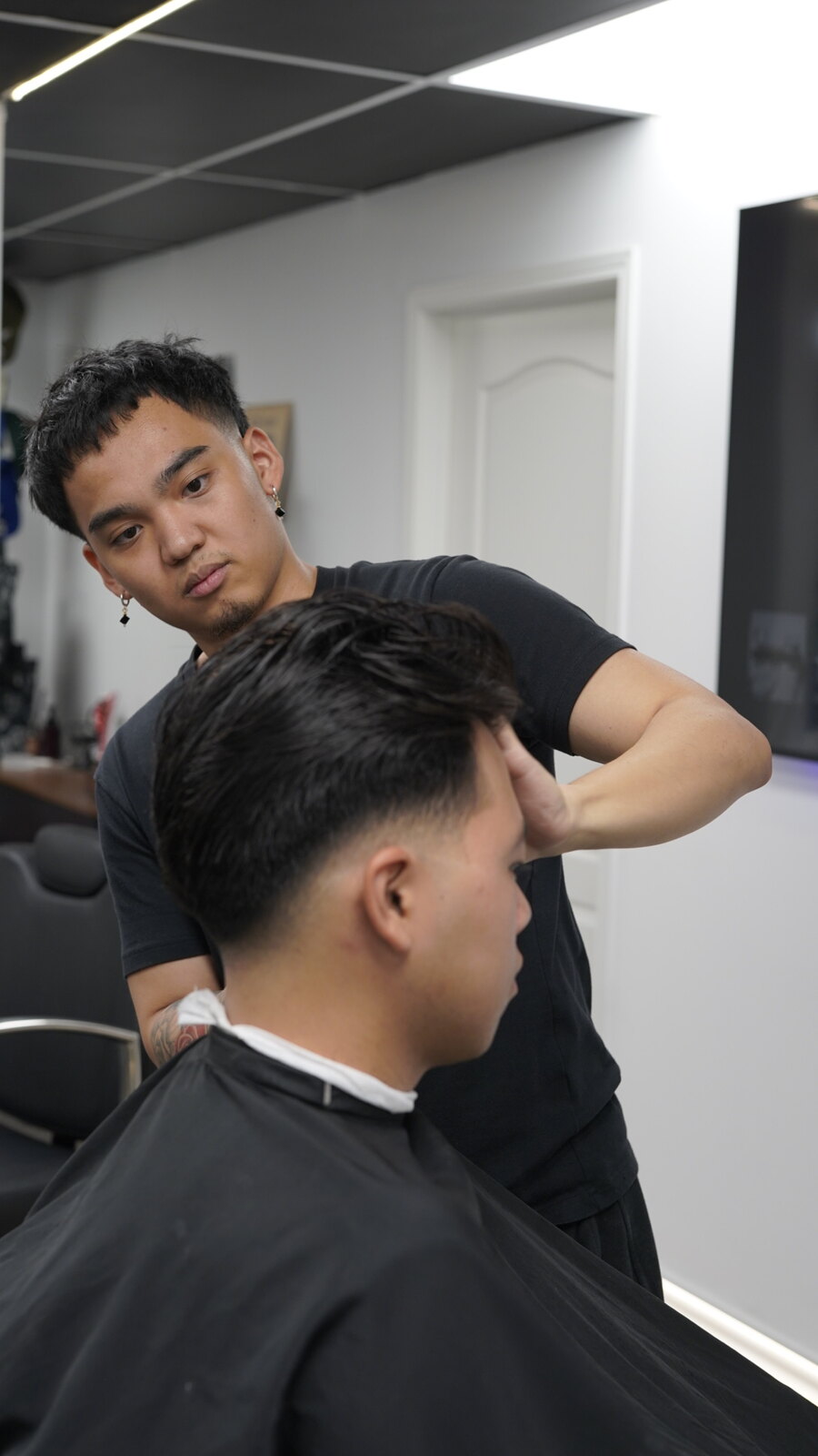 Barber finishing a client's haircut at fyf North